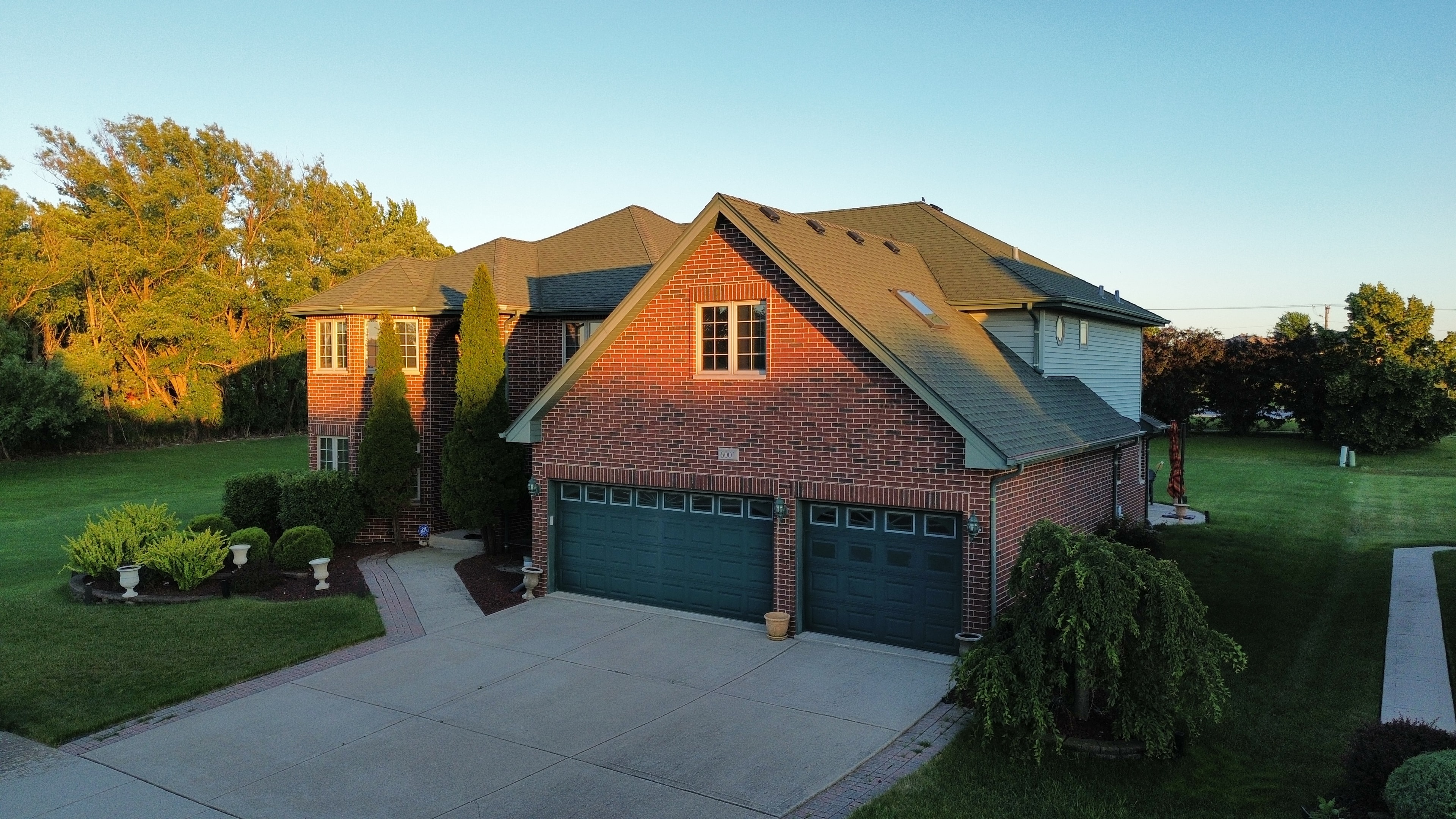 Aerial front view brick home golden hour