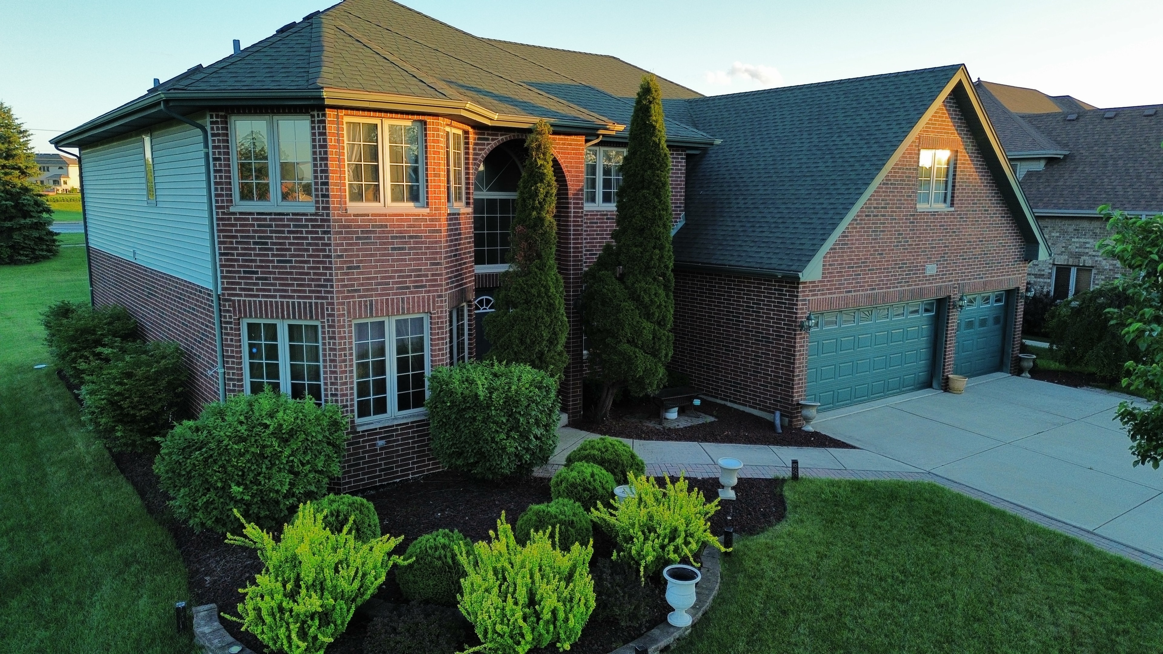 Aerial side view brick home with landscaping